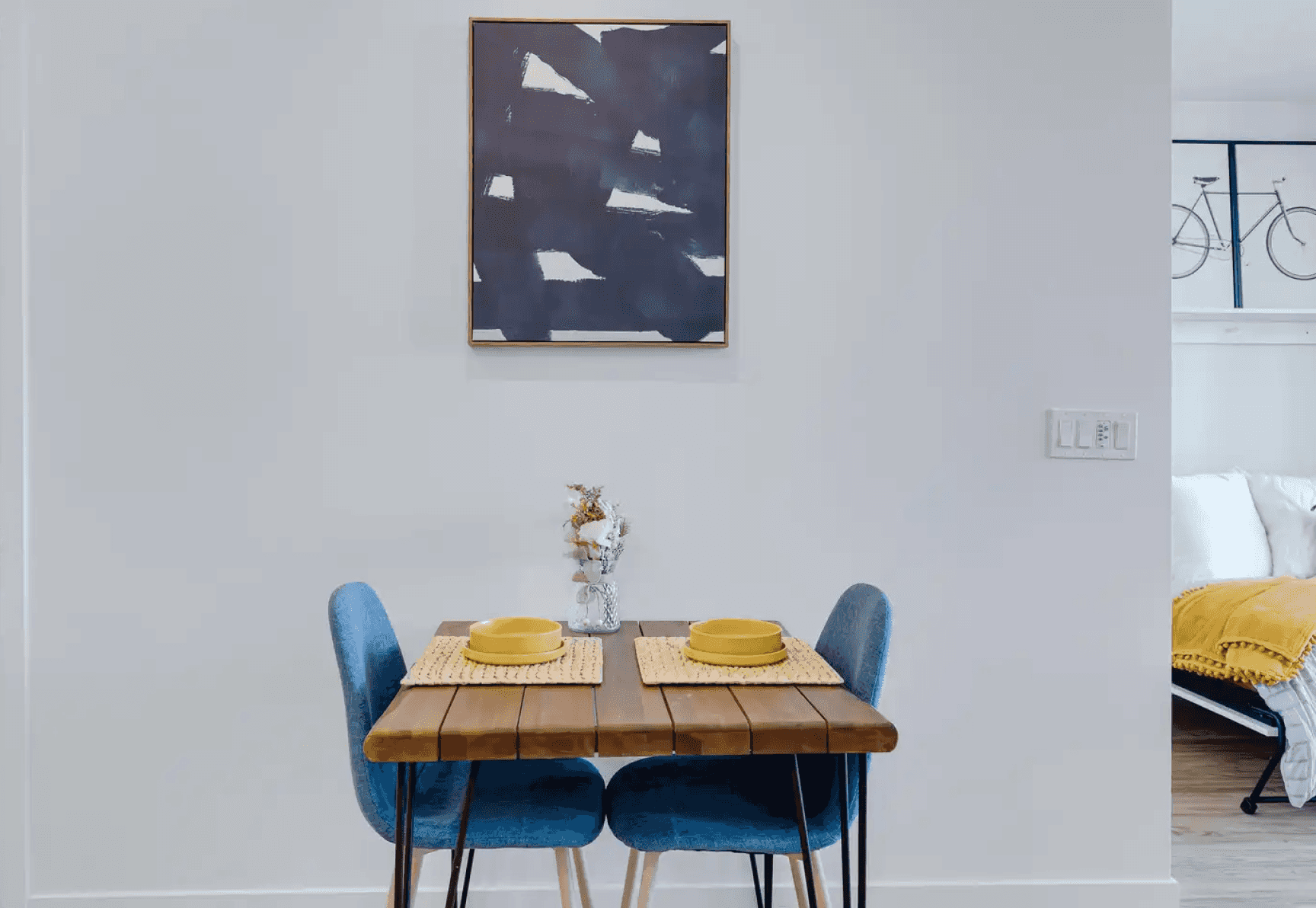 Set breakfast table with hung painting in the background