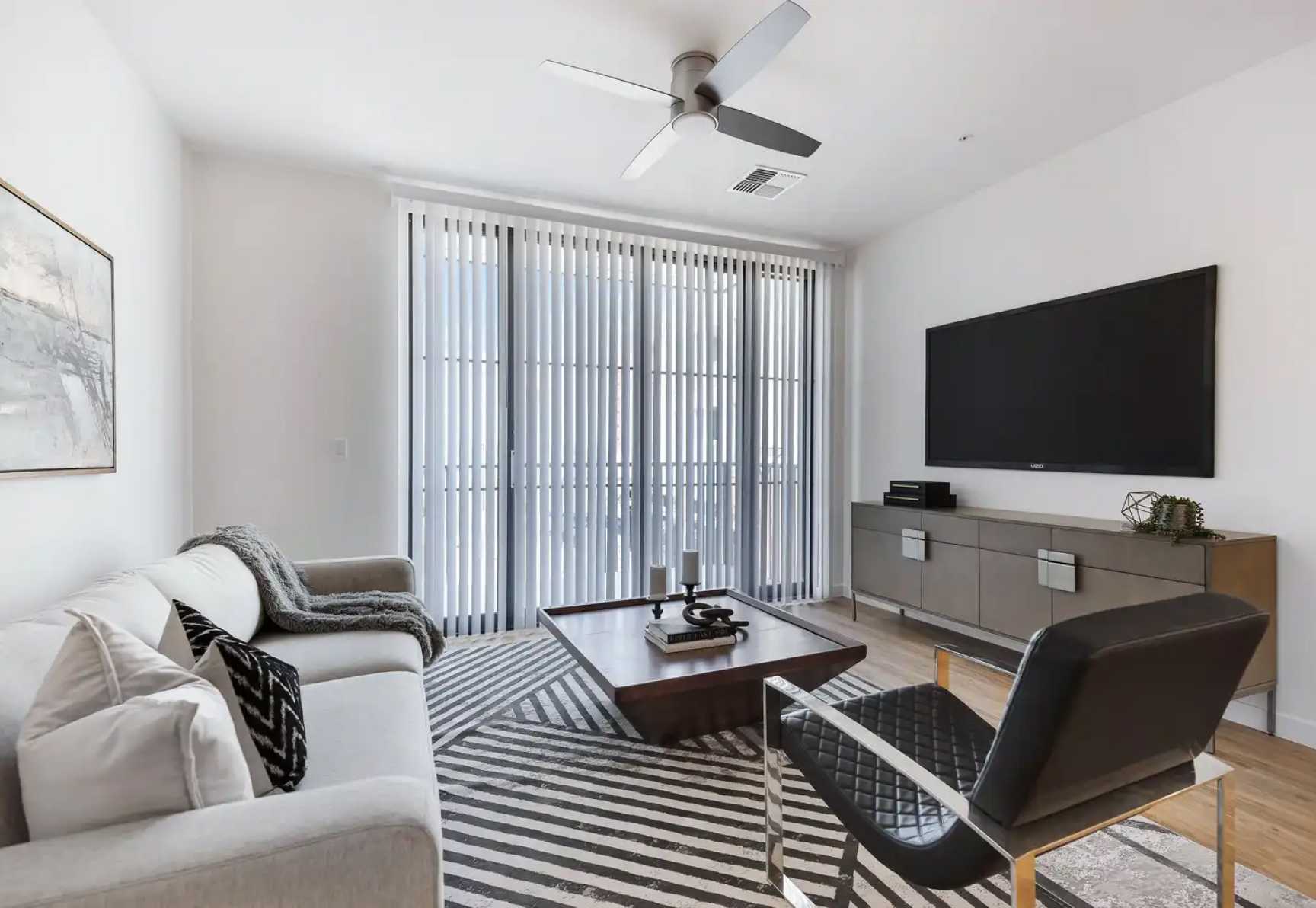 Living room with blinds closed and TV mounted on wall